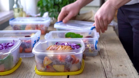 man packing his whole day meals in tiffin boxes