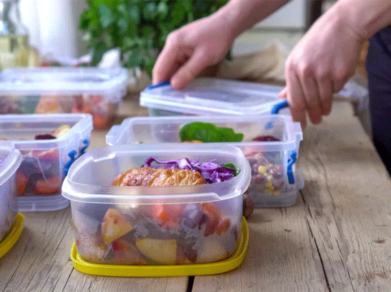 man packing his whole day meals in tiffin boxes
